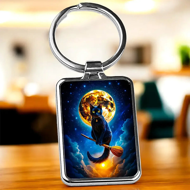 Porte-clé chat balai : chat noir sur balai sous lune orange étoilée