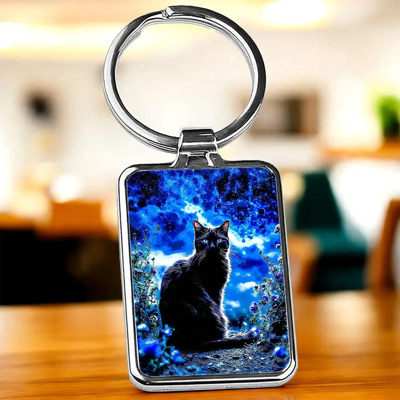 Porte-clé Chat Noir : chat noir sur fond cosmique bleu, cadre argenté