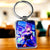 Porte-clé rectangulaire Keqing en argent avec illustration anime de personnage aux cheveux violets en robe bleu marine tenant une orbe luisante