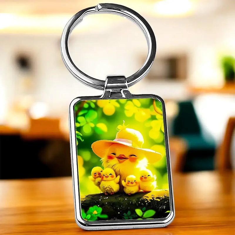 Porte-clé Poussin Famille : poussins jaunes sur fond vert feuillé, cadre argenté